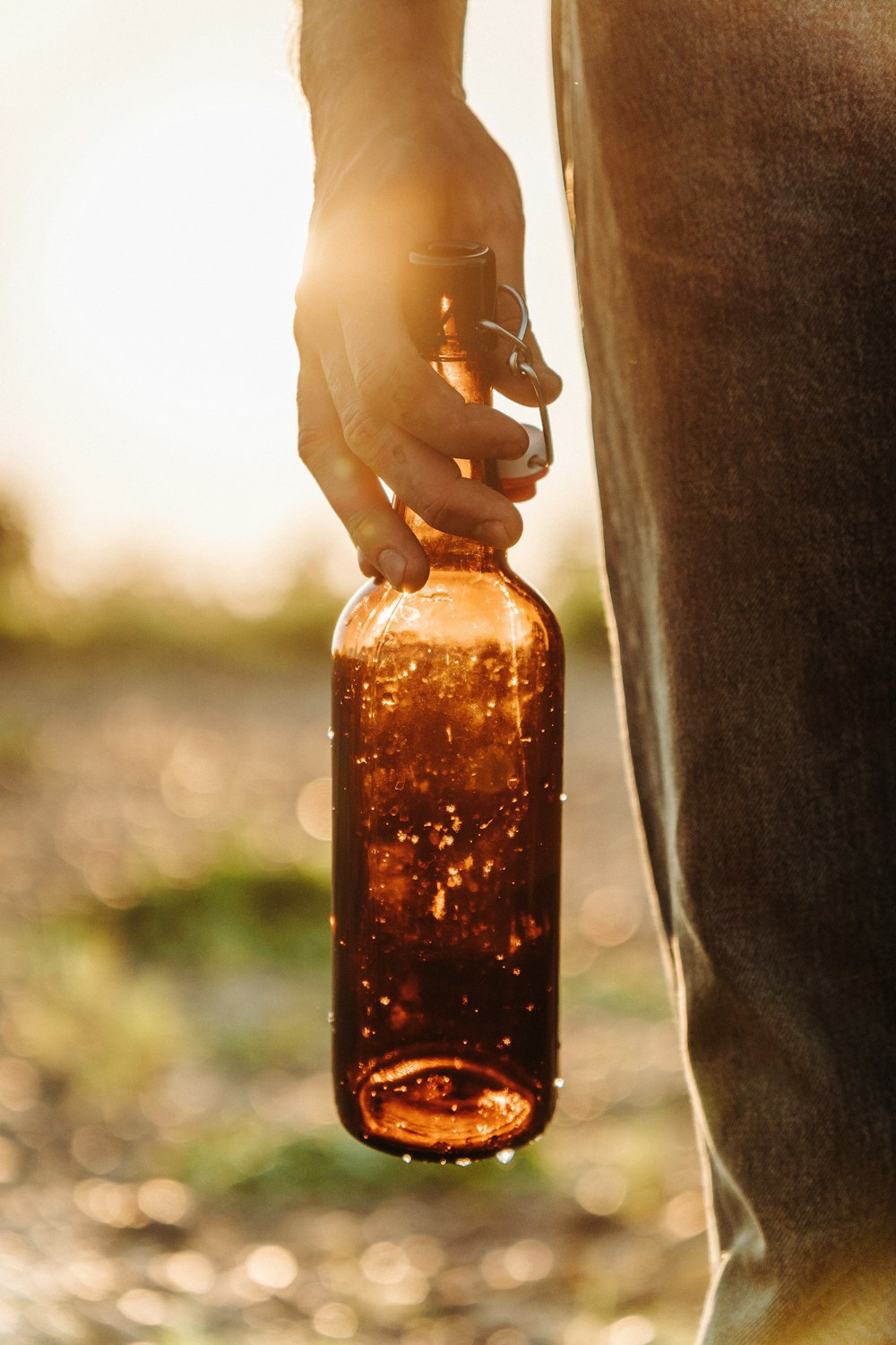 a person holding a brown bottle in their hand
