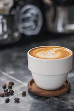 An influencer enjoying a freshly brewed cup of coffee in a cozy café setting, with coffee beans and brewing equipment in the background.