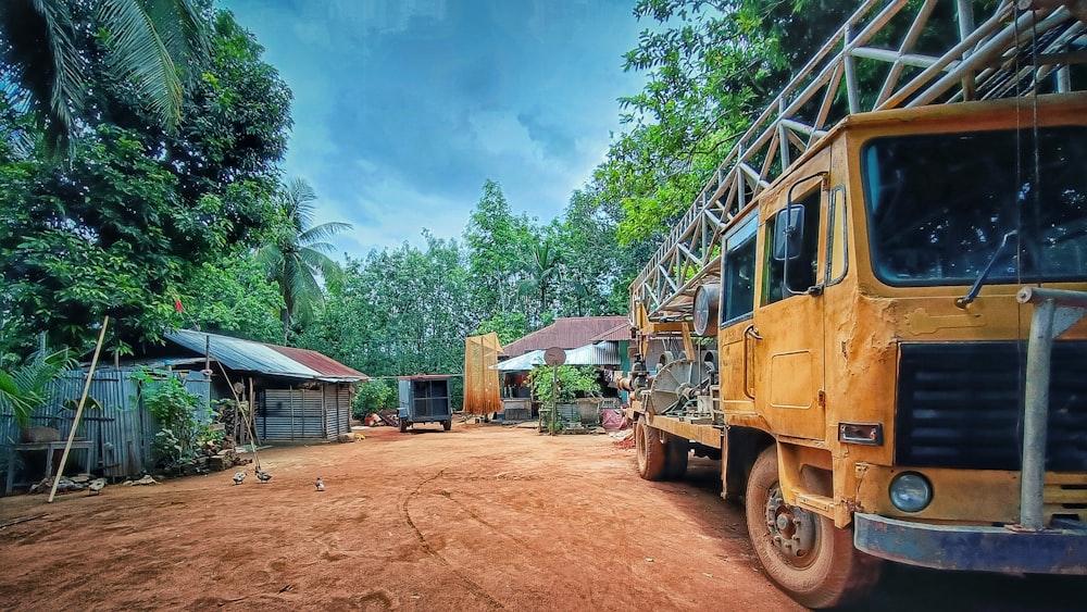 a yellow truck parked on a dirt road