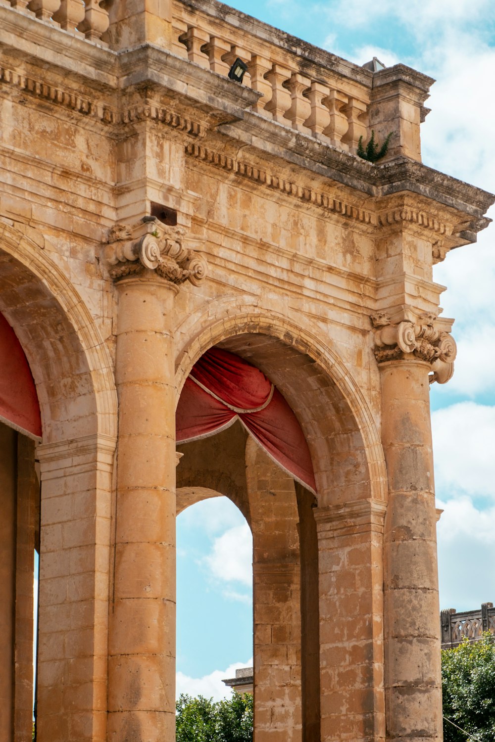 an old stone building with two arches and a red curtain