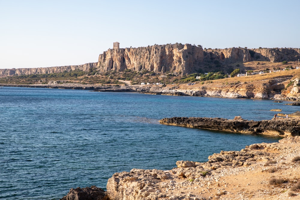 a large body of water near a rocky cliff