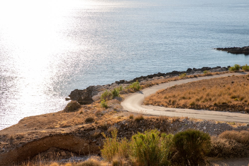 a car driving down a road next to a body of water