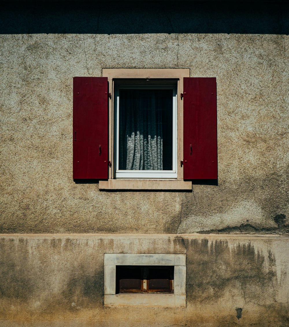 a window with red shutters on a building