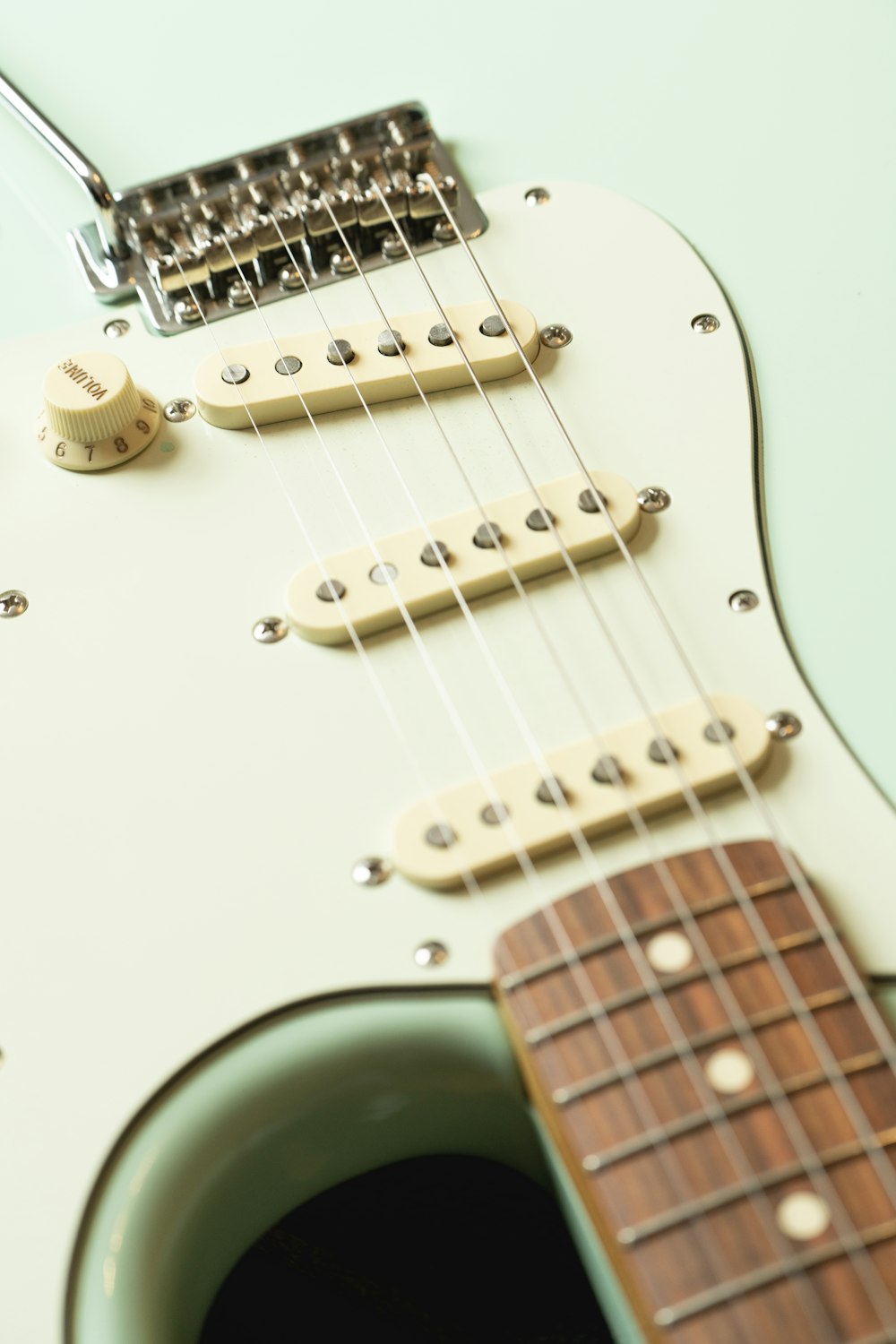 a close up of a white electric guitar