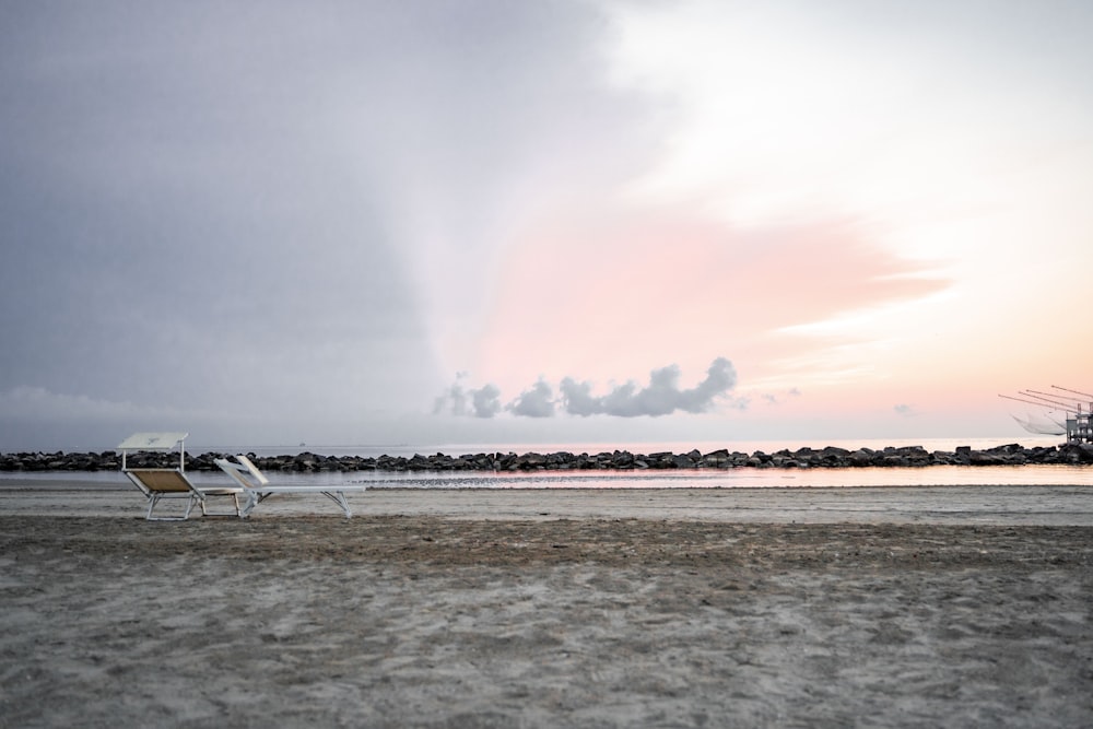 une chaise de plage assise sur le sable près de l’eau