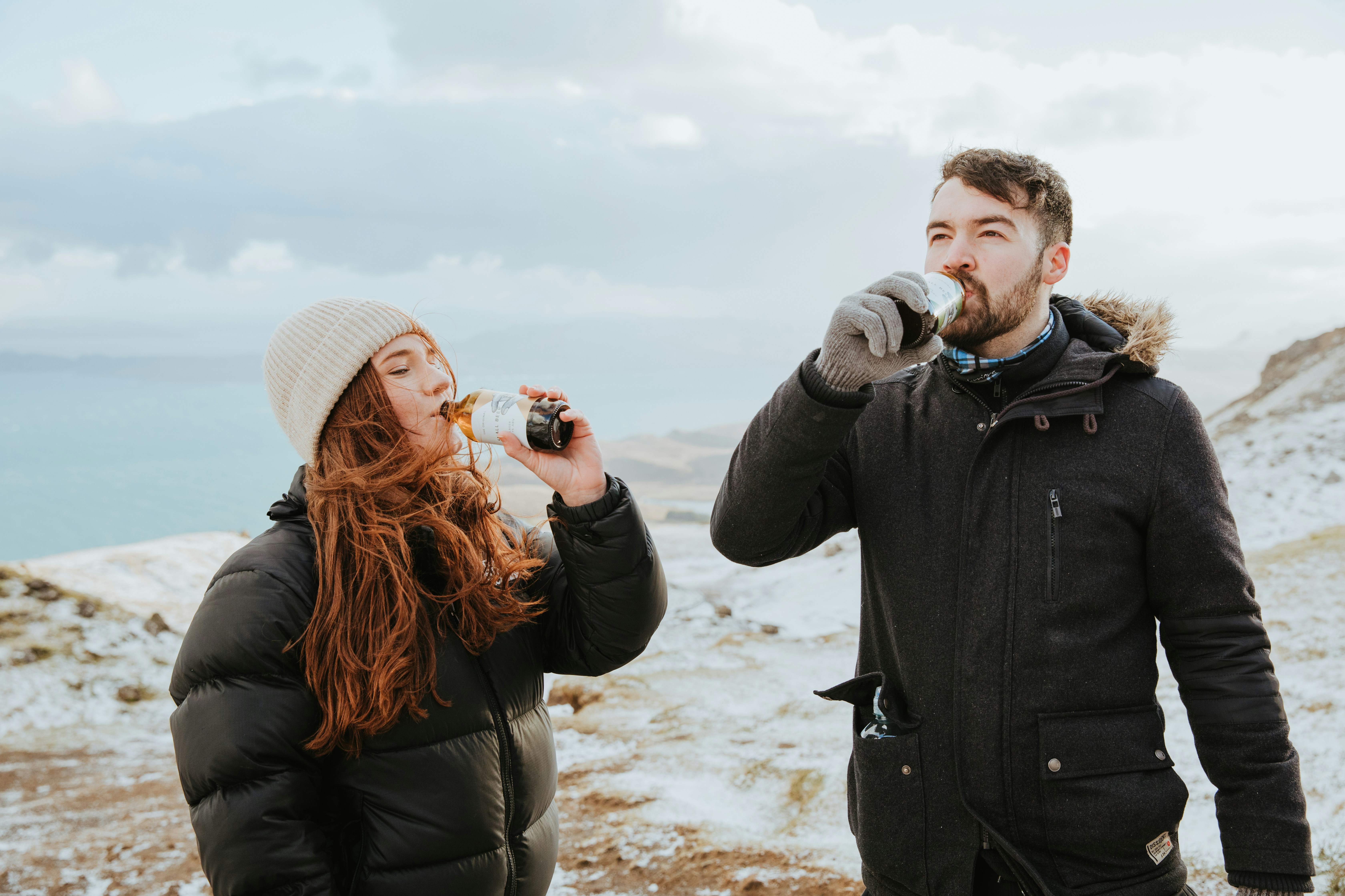 A man and a woman standing on top of a snow covered hill photo – Free ...