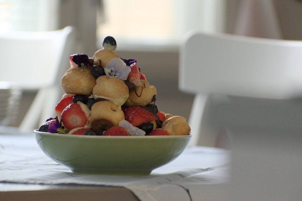 a bowl filled with fruit sitting on top of a table