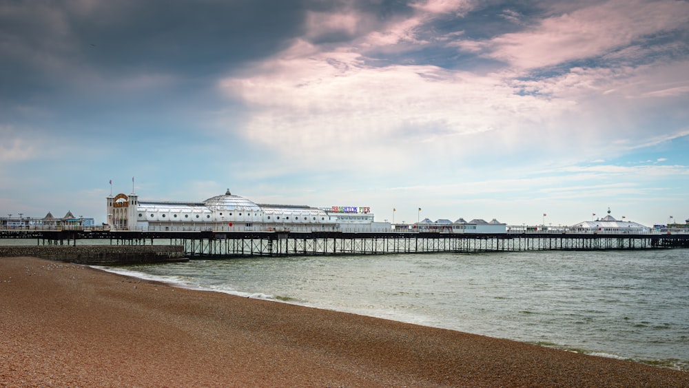 a pier on a beach with a large building in the background
