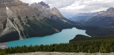 A scenic view of Moraine Lake with its turquoise waters surrounded by rugged mountains under a clear blue sky.