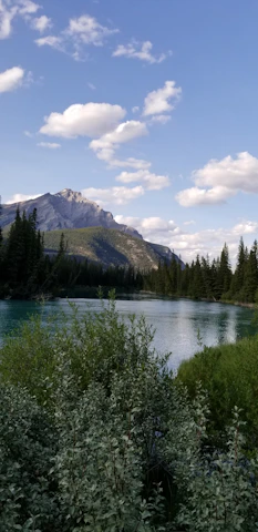 A serene mountain landscape with a winding river under a clear blue sky.