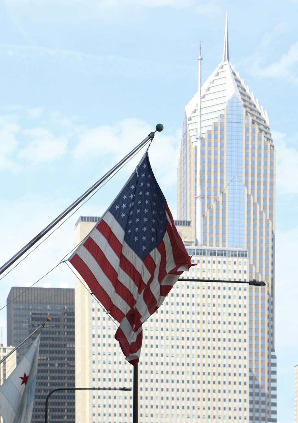 an american flag flying in front of a city skyline