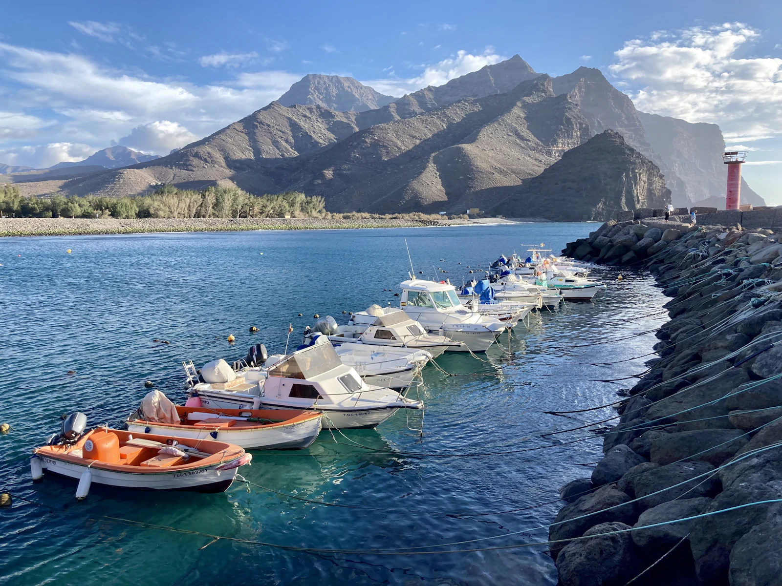 Barcas amarradas junto a un espigón, con las montañas de Gran Canaria al fondo