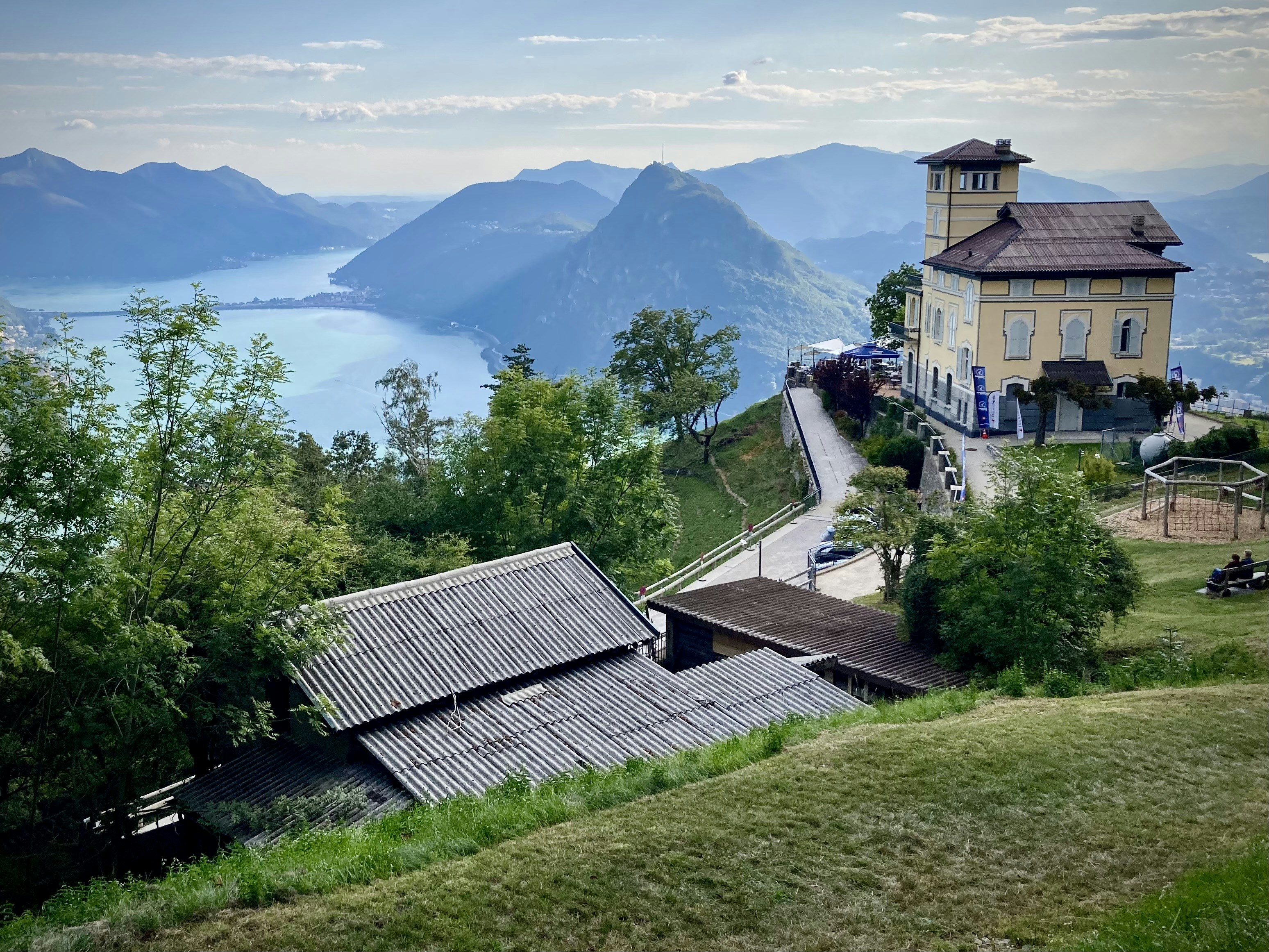 Ein Haus auf einem Hügel mit Blick auf einen See und Berge