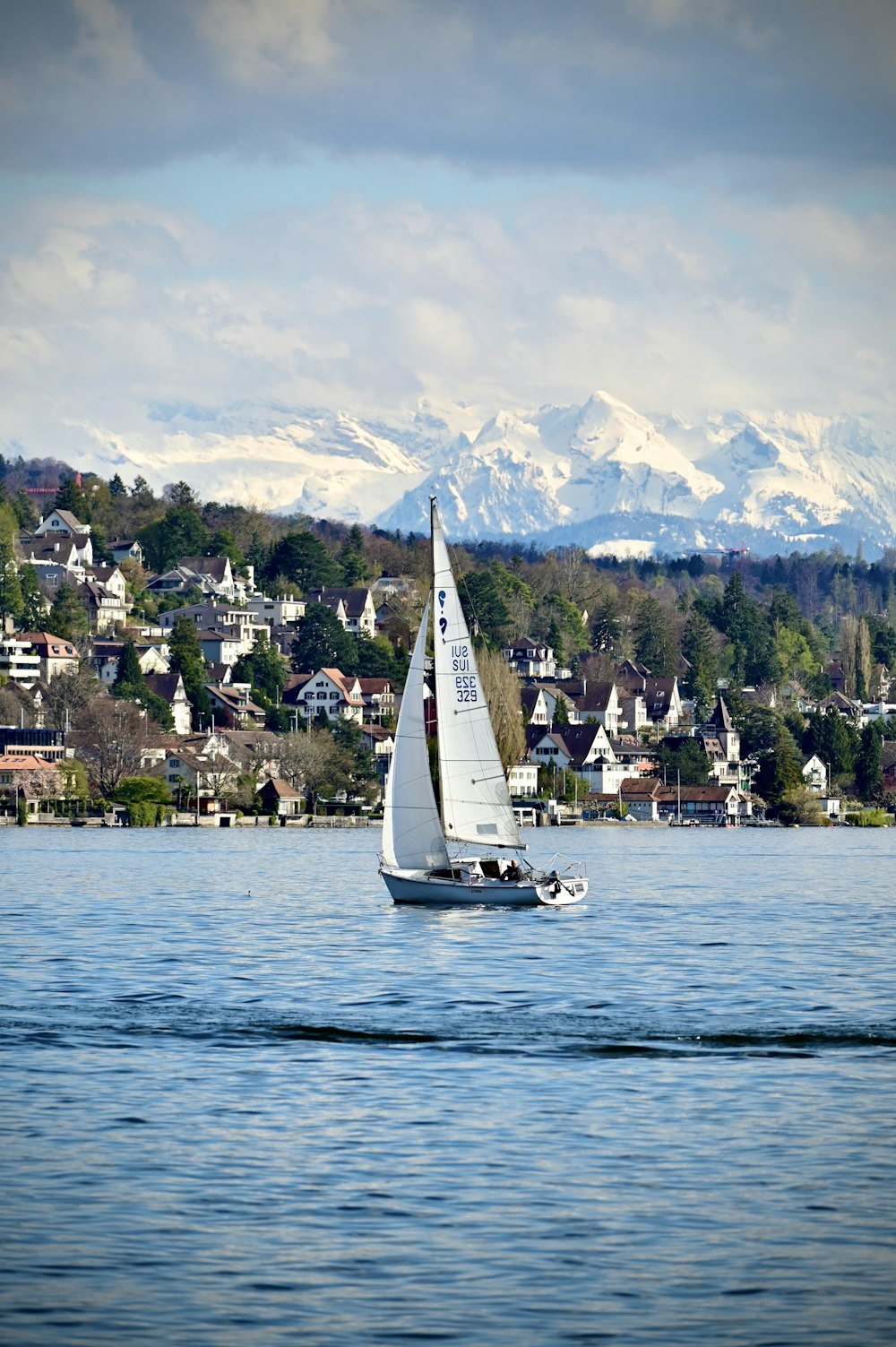 A sailboat sailing on a large body of water photo – Free Switzerland Image  on Unsplash