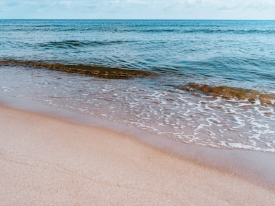 A tranquil beach scene with gentle waves lapping at the shore.
