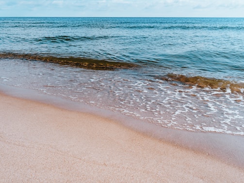 A tranquil beach scene with gentle waves lapping at the shore.