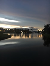 A serene lakefront property reflecting the sunset sky.