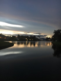 A serene lakefront property reflecting the sunset sky.