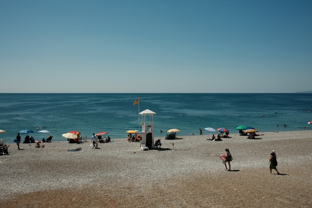 un groupe de personnes debout au sommet d’une plage de sable