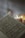 A sheet of music lies open with a vintage or classical look, featuring artistic illustrations amidst the musical notes. In the blurred background, several lit candles provide a warm, soft glow, adding an atmospheric depth to the scene.