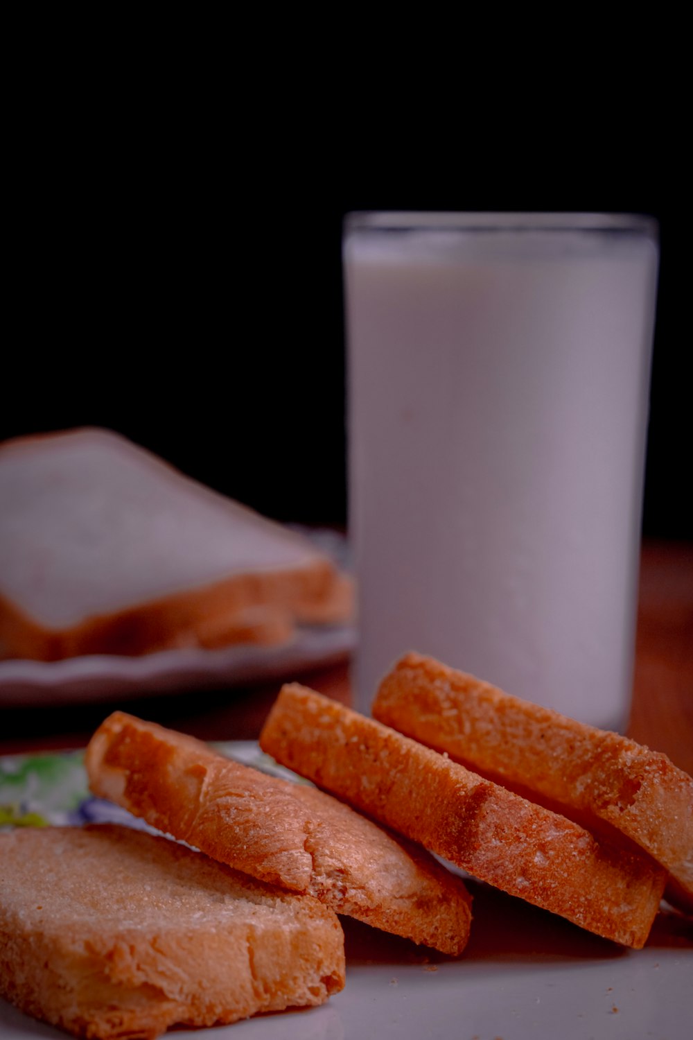 a white plate topped with sandwiches next to a glass of milk