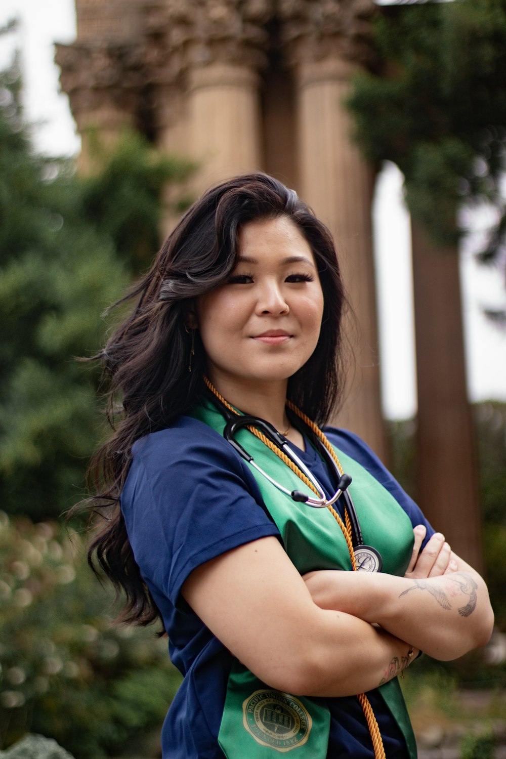 a woman with a stethoscope standing with her arms crossed