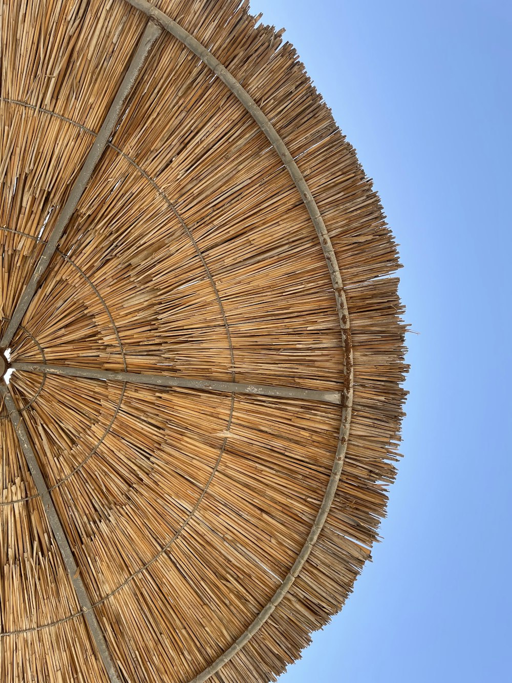 a straw umbrella with a blue sky in the background