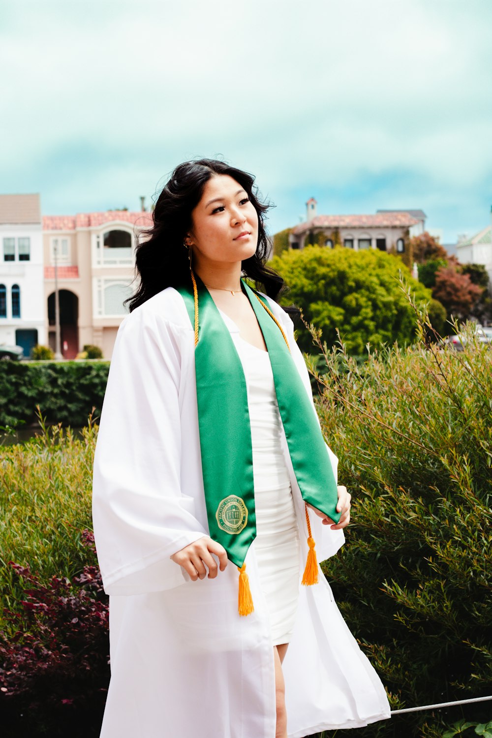 a woman in a white dress and green scarf