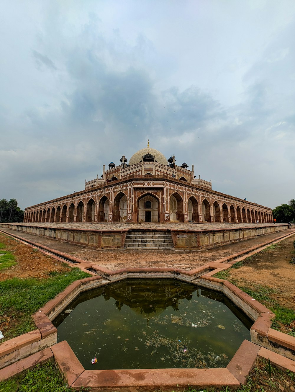 a large building with a pond in front of it