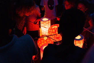 Children and parents engaged in creative workshops, crafting colorful paper lanterns and handmade items under soft evening light