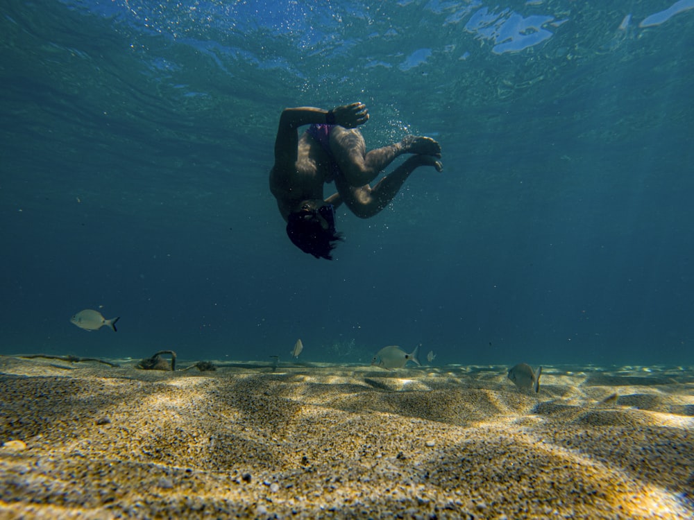 a man swimming in the ocean with a fish