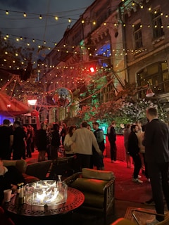 Black quick set glow disco tent lit up with colorful disco lights in a backyard party at dusk