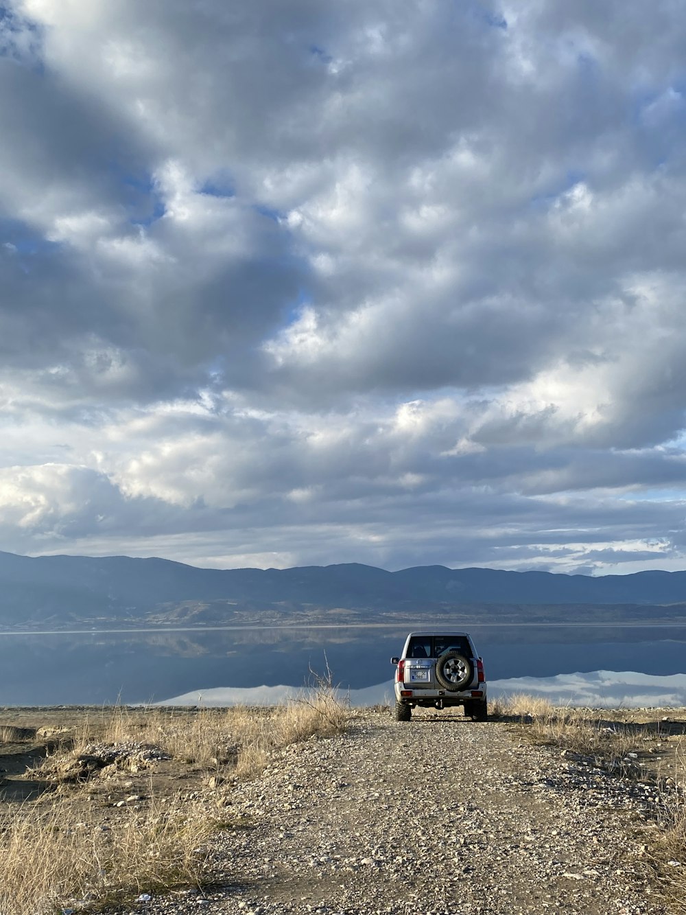 a truck parked on the side of a dirt road