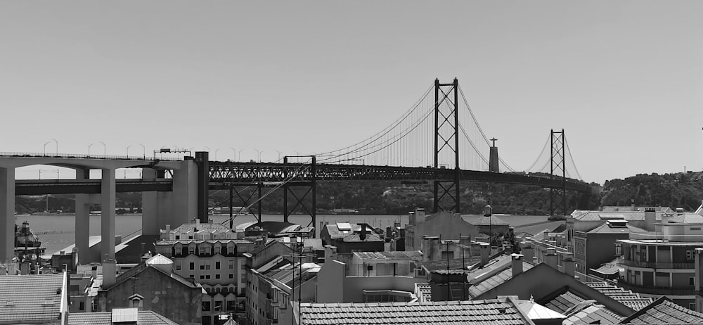 a black and white photo of a city with a bridge in the background