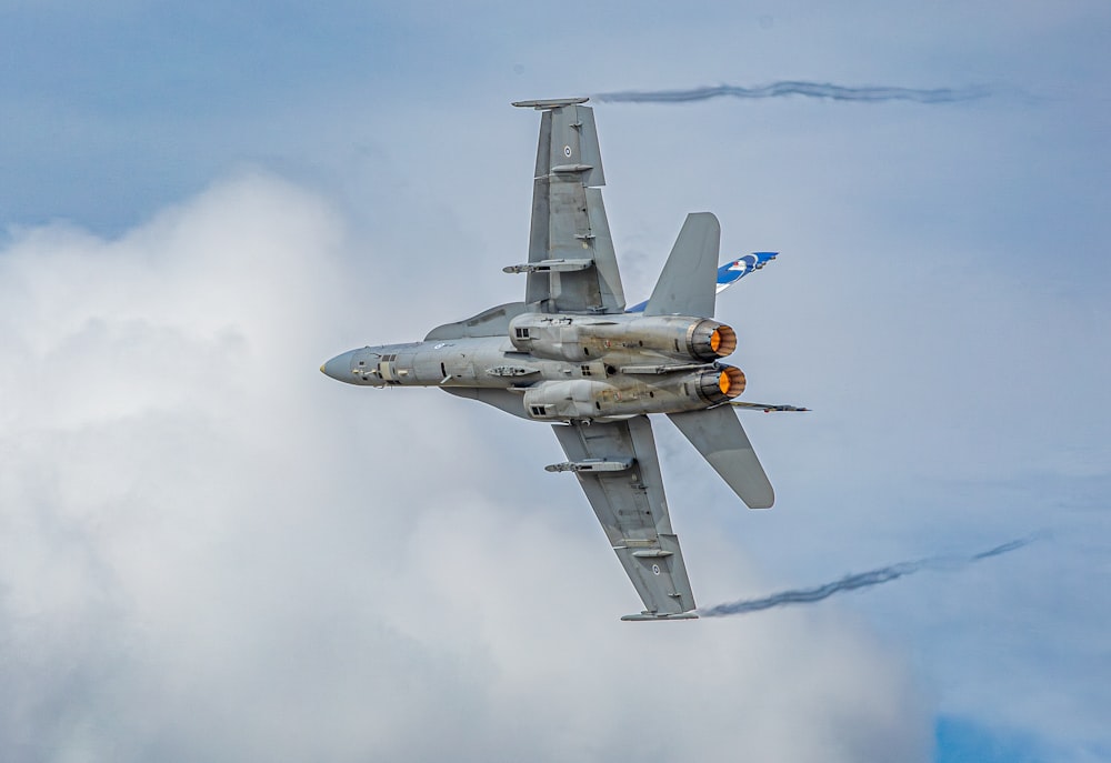 a fighter jet flying through a cloudy sky