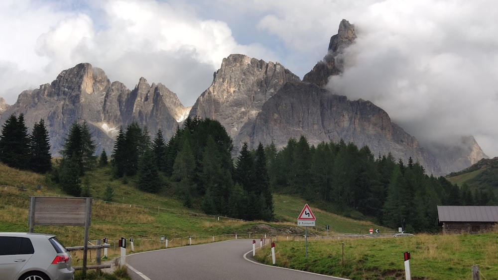 a car driving down a road in front of a mountain