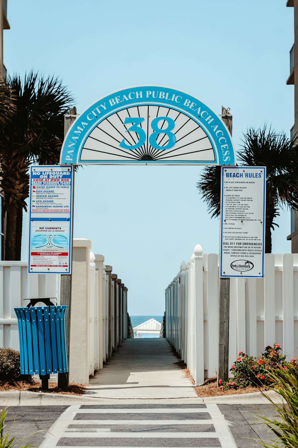 a white fence with a blue and white sign on it