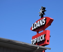 a sign for a top kick store against a blue sky