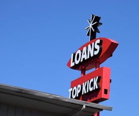 a sign for a top kick store against a blue sky
