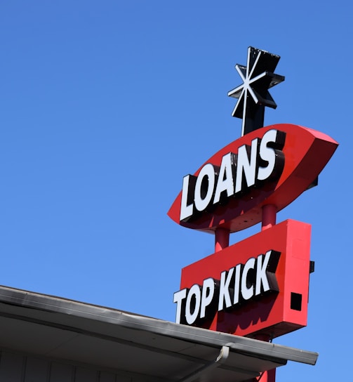 a sign for a top kick store against a blue sky