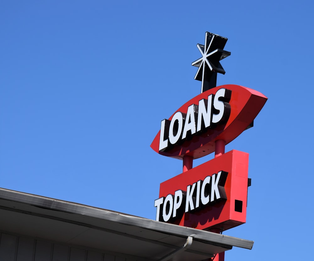 a sign for a top kick store against a blue sky