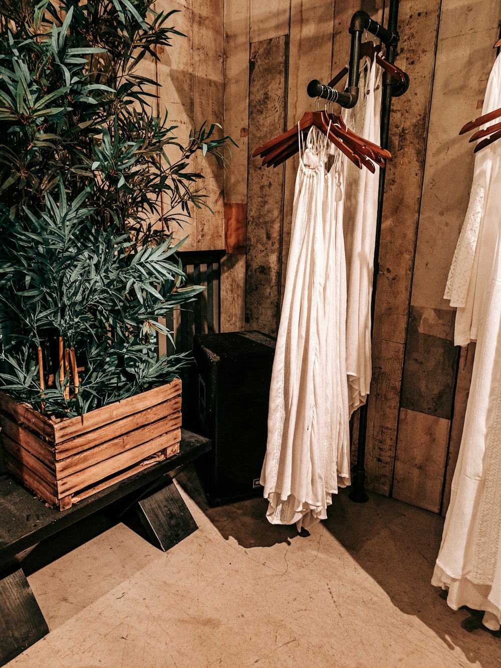 Un par de vestidos blancos colgados en un estante