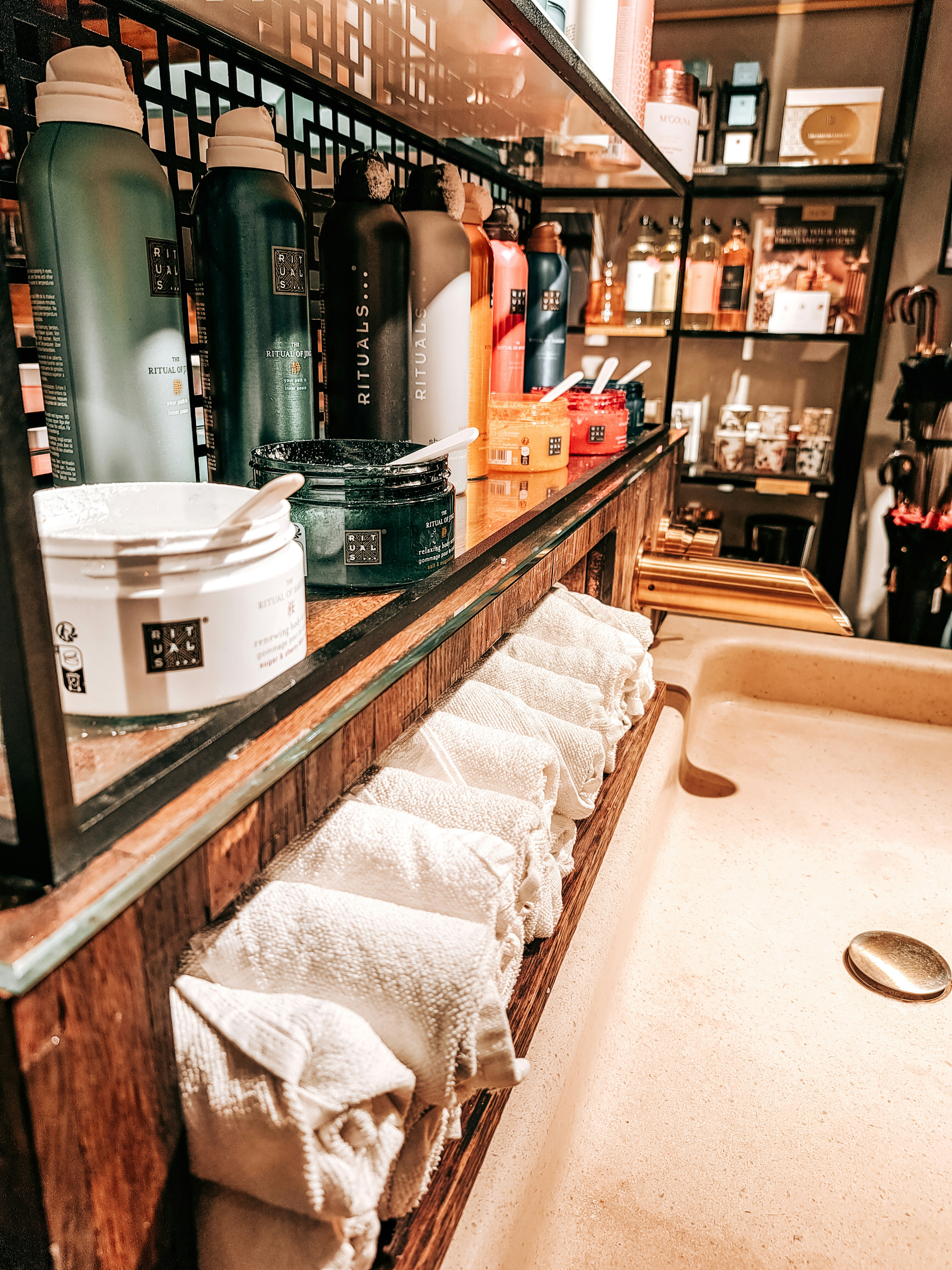 A bathroom with a tub and a shelf with towels photo – Free Rituals ...