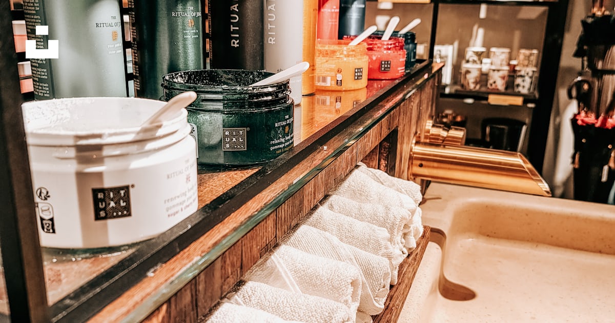 A bathroom with a tub and a shelf with towels photo – Free Rituals ...