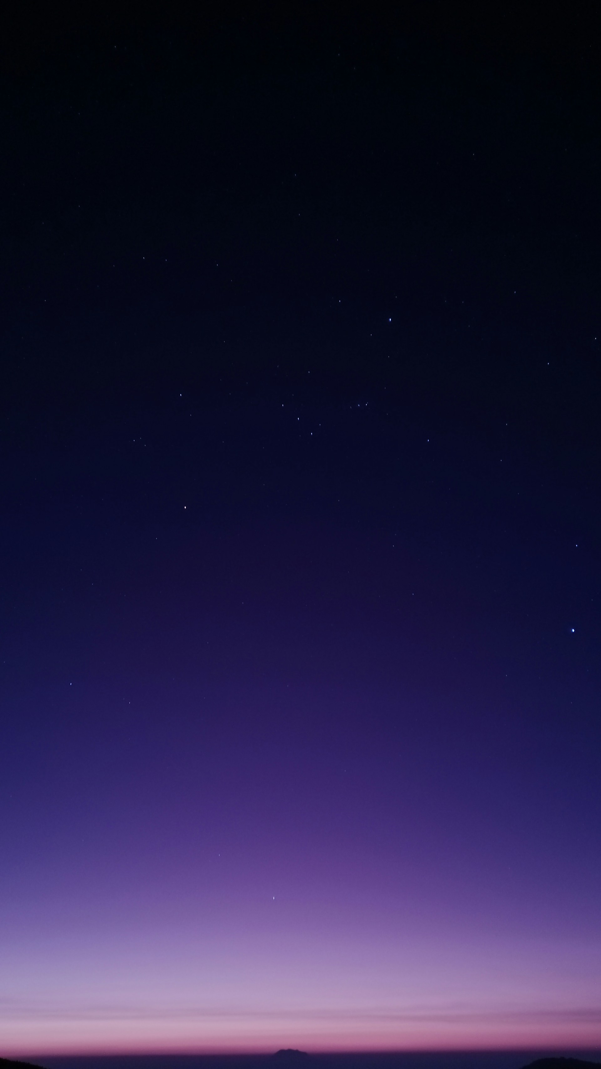 A deep purple twilight sky with shimmering golden stars forming mystical symbols.