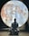 A person dressed in traditional attire sits in a meditative pose on a wooden floor, silhouetted against a large, illuminated image of the moon. The setting appears serene and contemplative, with the moon's detailed surface providing atmospheric lighting.