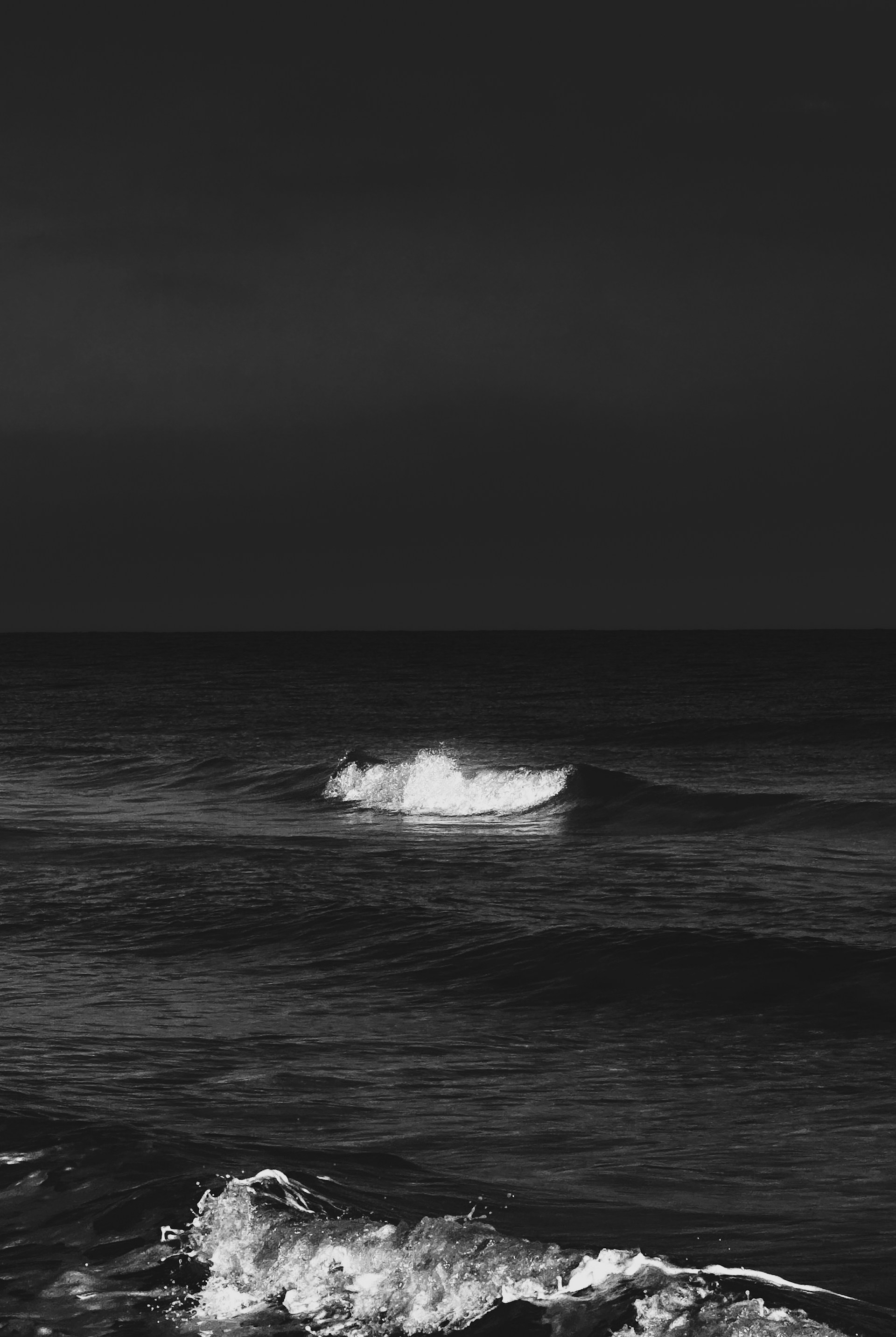 a black and white photo of a wave in the ocean