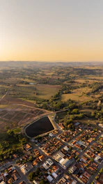 Aerial view of spacious, well-marked residential lots surrounded by greenery under a clear sky.