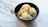 A rustic bowl filled with creamy vanilla artisanal ice cream topped with fresh vanilla beans.