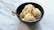 A rustic bowl filled with creamy vanilla artisanal ice cream topped with fresh vanilla beans.
